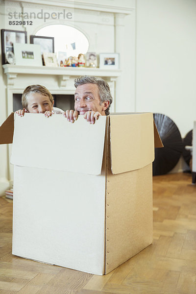 Vater und Sohn spielen im Karton