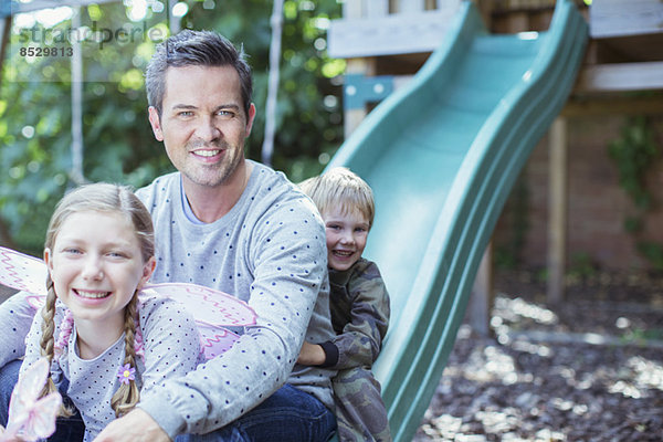 Vater und Kinder spielen auf einer Spielanlage