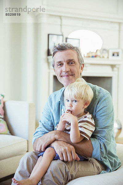 Vater hält Sohn im Wohnzimmer