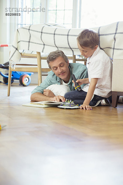 Vater und Sohn lesen im Schlafzimmer