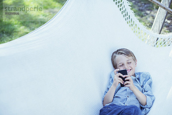 Junge mit Handy in der Hängematte