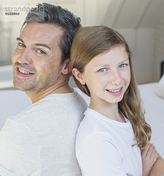 Vater und Tochter lächeln im Schlafzimmer