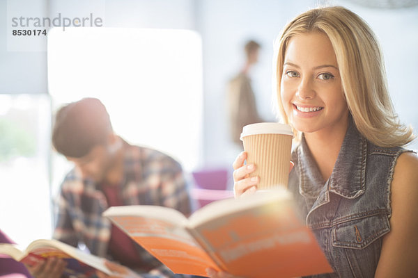 Universitätsstudent beim Lesen und Kaffeetrinken