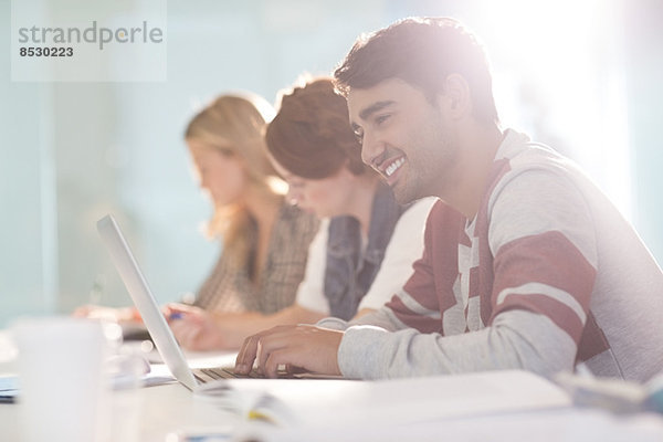 Universitätsstudent mit Laptop im Klassenzimmer