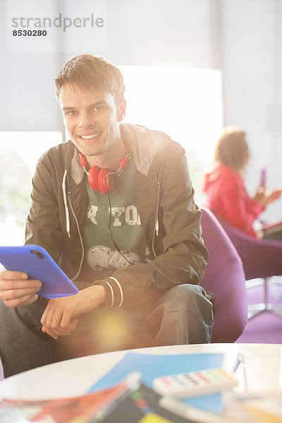 Universitätsstudent mit digitalem Tablett in der Lounge