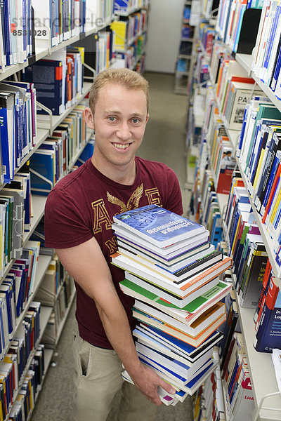 Student mit Bücherstapel in der Bereichsbibliothek der Universität Hohenheim  Stuttgart  Baden-Württemberg  Deutschland