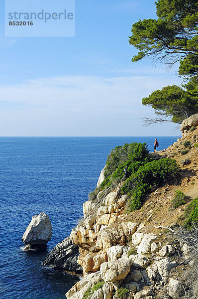 Woman hiking on the cliffs  near Deia  Sierra de Tramuntana  Majorca  Balearic Islands  Mediterranean  Spain