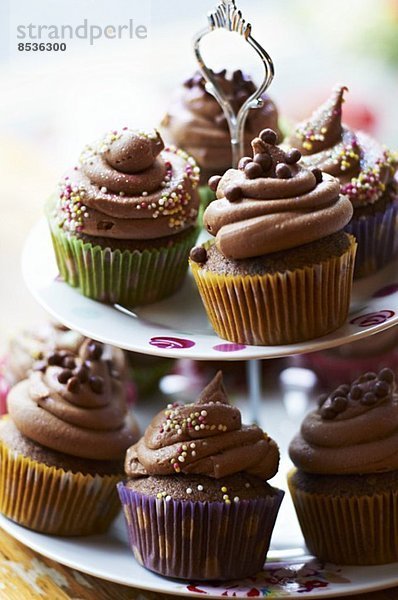 Schokoladen-Cupcakes mit Zuckerperlen auf Etagere