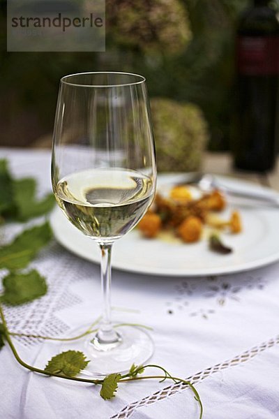 Ein Glas Weißwein auf einem herbstlichem Tisch
