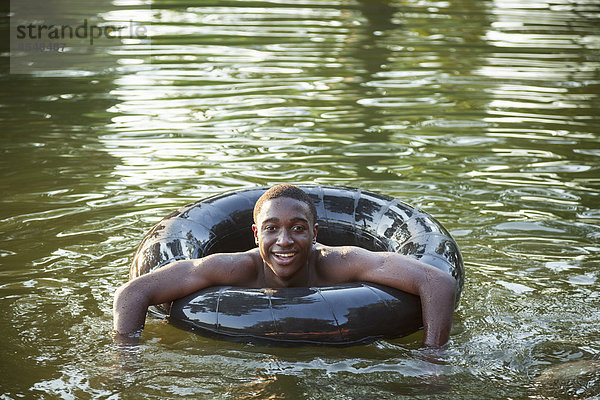 Ein Junge  der mit einem Reifen im Wasser schwimmt  schwimmt im Wasser.