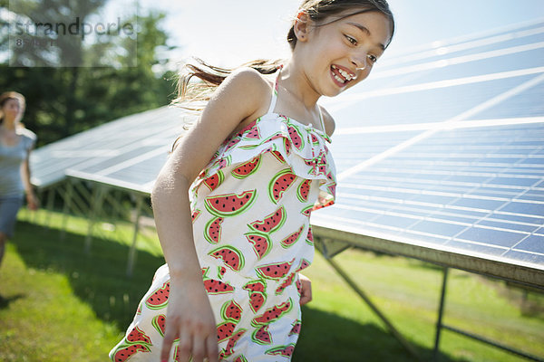 Ein Kind und seine Mutter an der frischen Luft  neben Sonnenkollektoren an einem sonnigen Tag auf einer Farm im Staat New York  USA.