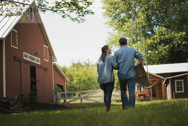 Zwei Menschen  Mann und Frau auf dem Hof eines traditionellen Bauernhofs in den USA.