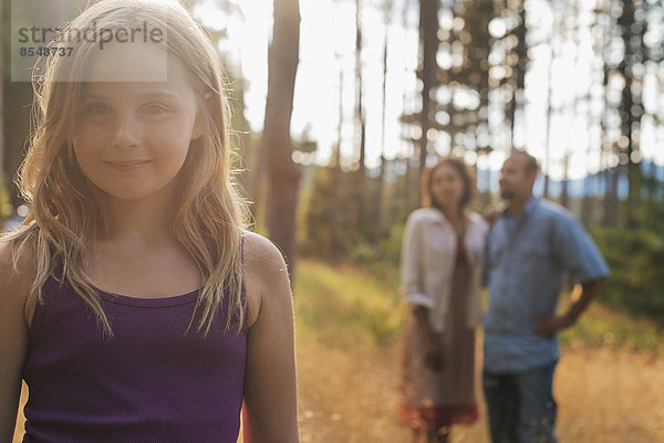 Ein junges Mädchen mit langen blonden Haaren im Wald an der frischen Luft.
