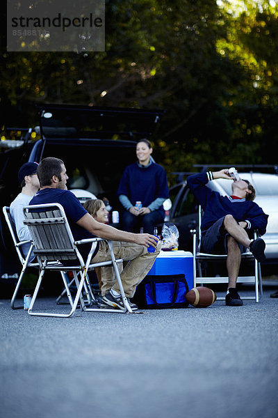 Eine Gruppe von Freunden bei einem Barbecue oder einer Heckparty bei einer Veranstaltung.
