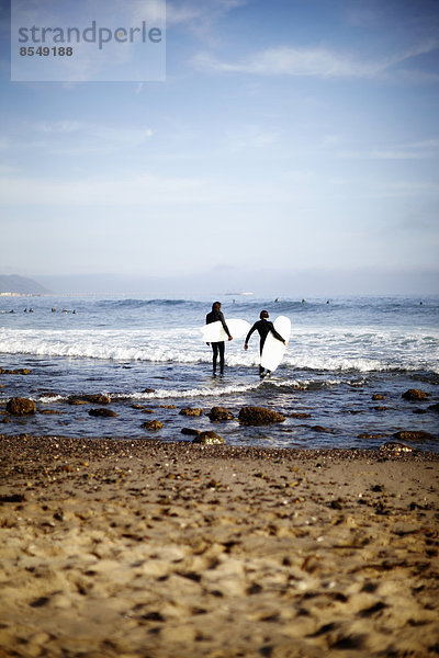 Zwei Surfer am Wasser bei der Inspektion der Wellen am Rockport Beach  USA