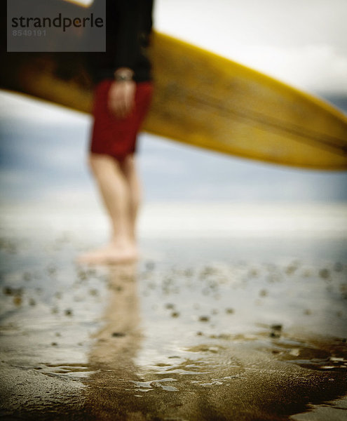 Ein Mann mittleren Alters beim Surfen in Neuengland am Rockport Beach.