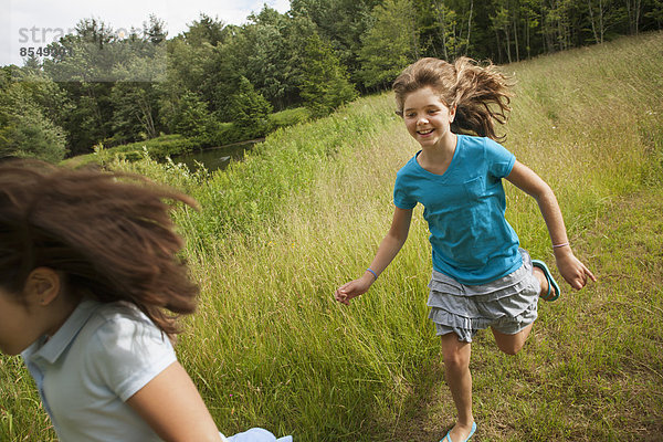 Zwei Kinder  Mädchen  die jagen und einen Weg entlang rennen.