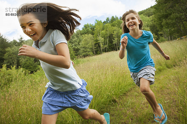 Zwei Kinder  rennende und jagende Mädchen  die an der frischen Luft lachen.