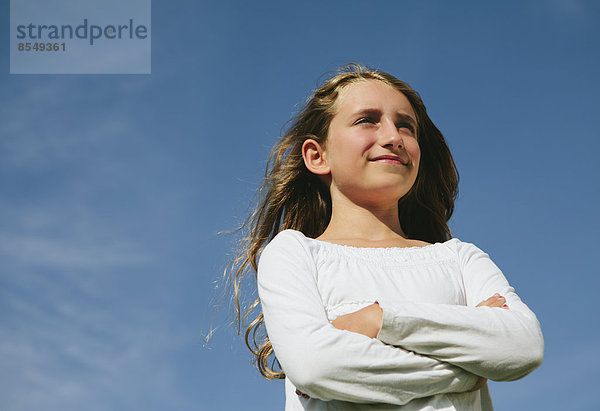 Porträt eines selbstbewussten und glücklichen neunjährigen Mädchens  im Freien