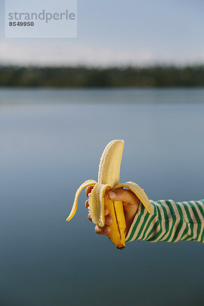 Neunjähriges Mädchen mit biologischer  geschälter Banane