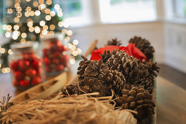 Rote Glaskugeln und Tannenzapfen. Weihnachtsschmuck und ein Weihnachtsbaum.