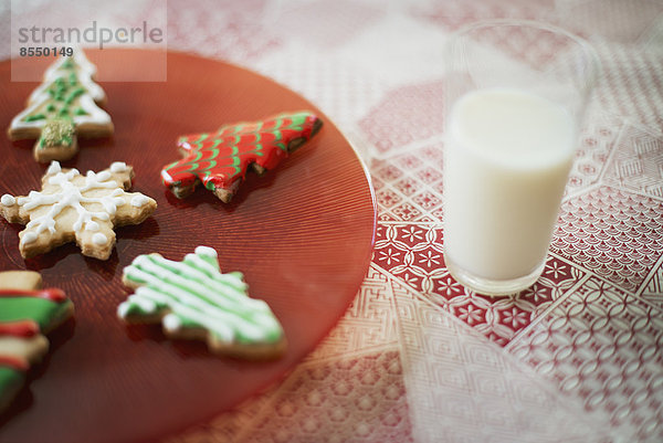 Hausgemachte Bio-Weihnachtsplätzchen und ein Glas Milch.