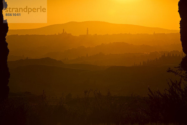 Sonnenuntergang über den Hügeln der Toskana  hinten Siena  Toskana  Provinz Siena  Italien