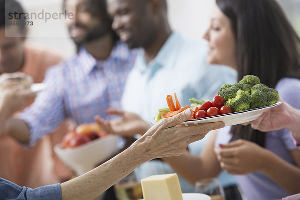 Ein Großraumbüro in New York City. Ein Arbeitsessen  ein Salatbuffet. Eine Gruppe von Männern und Frauen gemischten Alters und unterschiedlicher ethnischer Herkunft  die zusammenkommen.