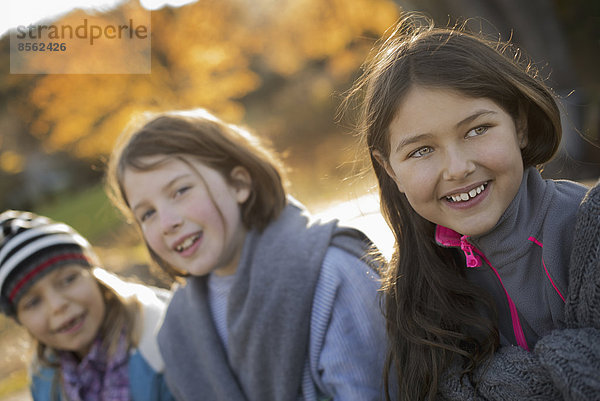 Drei junge Mädchen  Kinder  draußen an der frischen Luft. Herbstliches Laub.