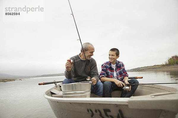 Ein Tagesausflug am Ashokan-See. Ein Mann und ein Junge sitzen beim Angeln vom Boot aus.