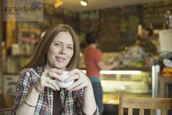 Ein Café und Cafe in High Falls namens The Last Bite. Zwei Personen im Hintergrund und eine Frau  die an einem Tisch sitzt.