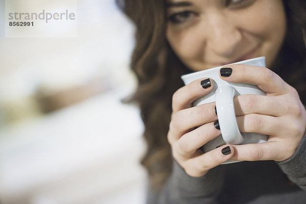 Frau entspannt sich zu Hause bei Kaffee