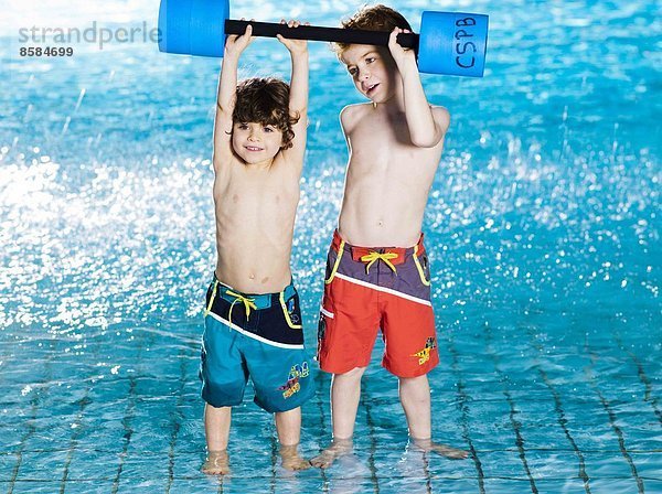 Zwei Jungen mit Schaumstoffhanteln im Schwimmbad