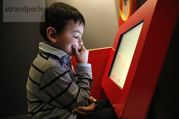Junge spielt mit einem Computer in der Cité des Sciences  Paris  Frankreich.