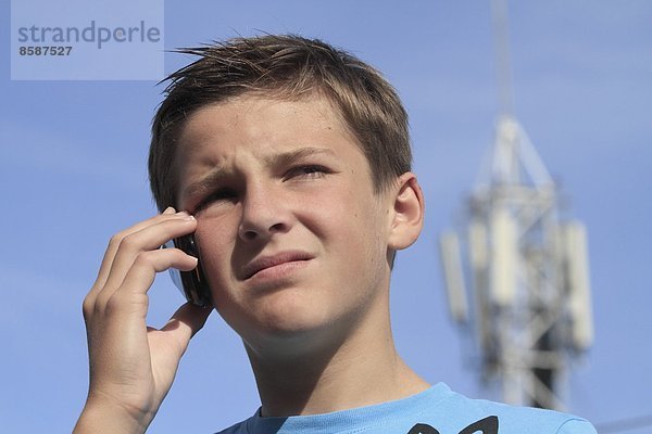 Frankreich  kleiner Junge am Telefon  Telefonrelaisantenne im Hintergrund.