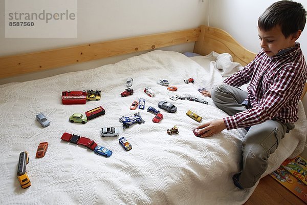 Ein 7-jähriger Junge spielt auf seinem Bett. Frankreich.
