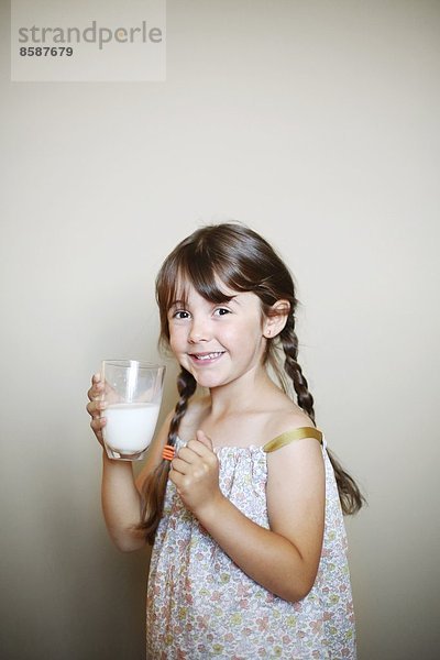 Ein kleines Mädchen mit einem Glas Milch.