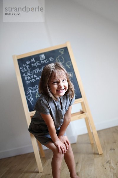 Ein kleines Mädchen vor einer Tafel