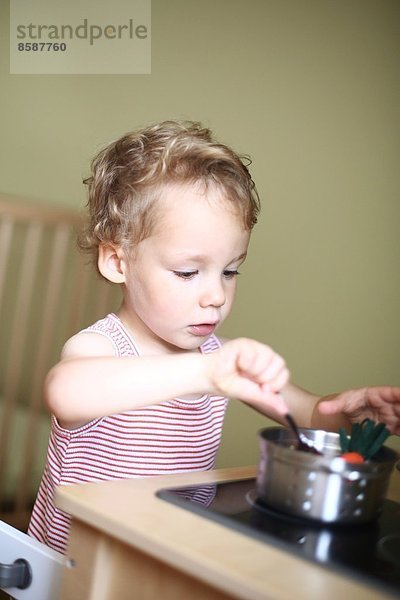 Ein kleiner Junge spielt mit dem Geschirrset