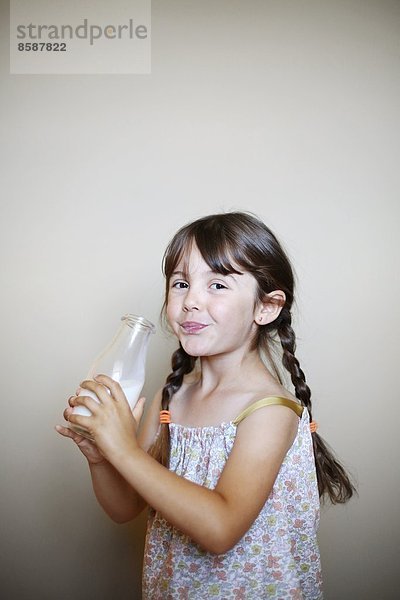 Ein kleines Mädchen mit einer Flasche Milch.
