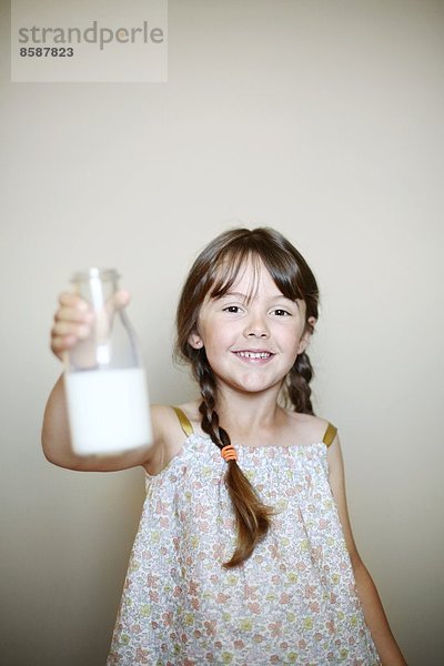 Ein kleines Mädchen mit einer Flasche Milch.