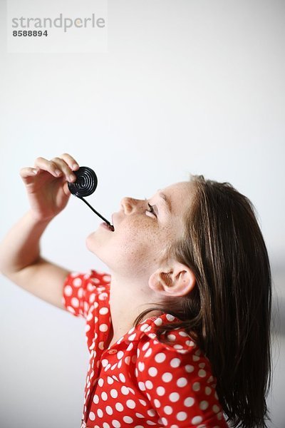 ein kleines Mädchen spielt mit Lakritz