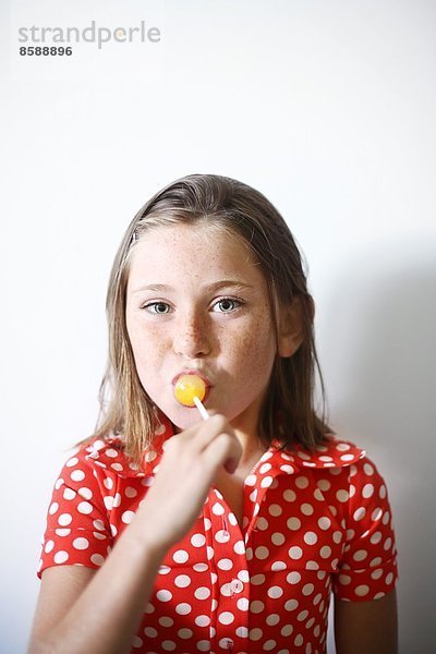 ein kleines Mädchen  das einen Lolli isst.