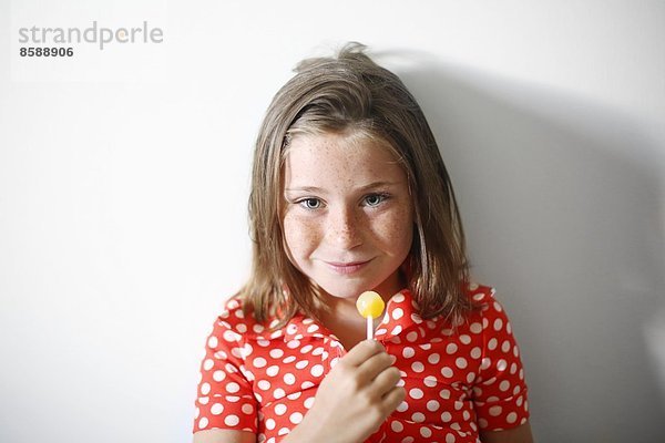 ein kleines Mädchen  das einen Lolli isst.