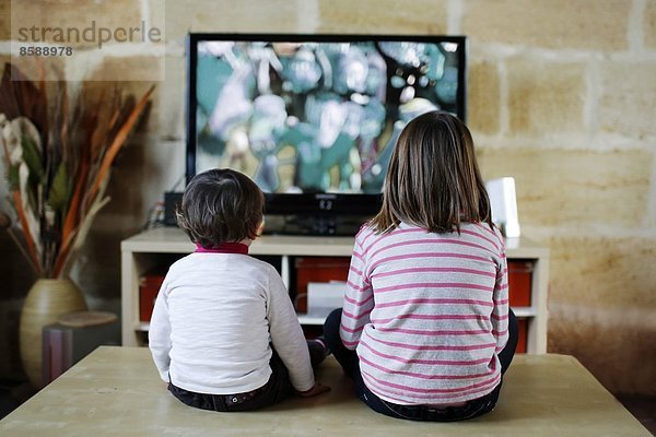 Zwei kleine Mädchen vor dem Fernseher