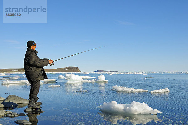 Mann vom Volk der Inuit angelt am Ufer der Beaufort Sea  Nordpolarmeer  Victoria Island  früher Holman Island  Dorf Ulukhaktok  Northwest Territories  Kanada