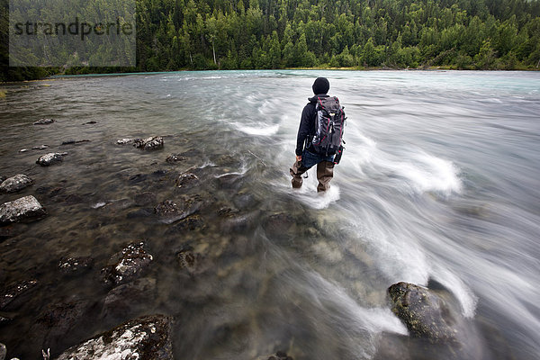 Mann steht mit Fischerstiefeln am Ufer des Lowe River bei Valdez  Alaska  USA