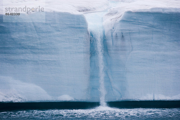 Ein Wasserfall wird von einem schmelzenden Eisberg erzeugt  Svalbard  Norwegen