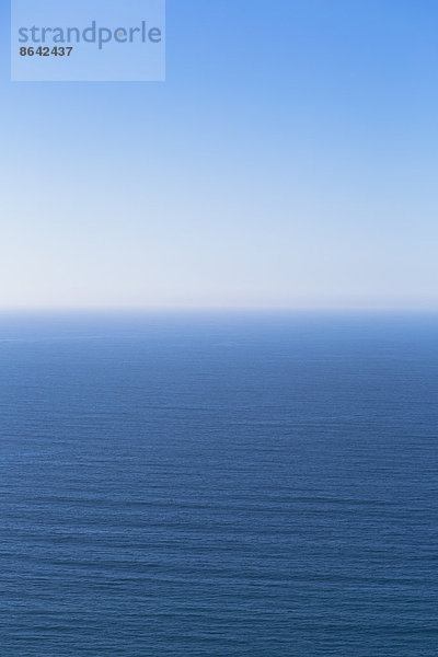 Ein Blick über den Pazifischen Ozean und eine ruhige See  die in den blauen Himmel übergeht.