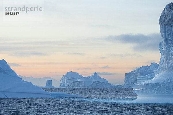 Hohe skulptierte Eissäulen  die in einem Fjord im Meer treiben.